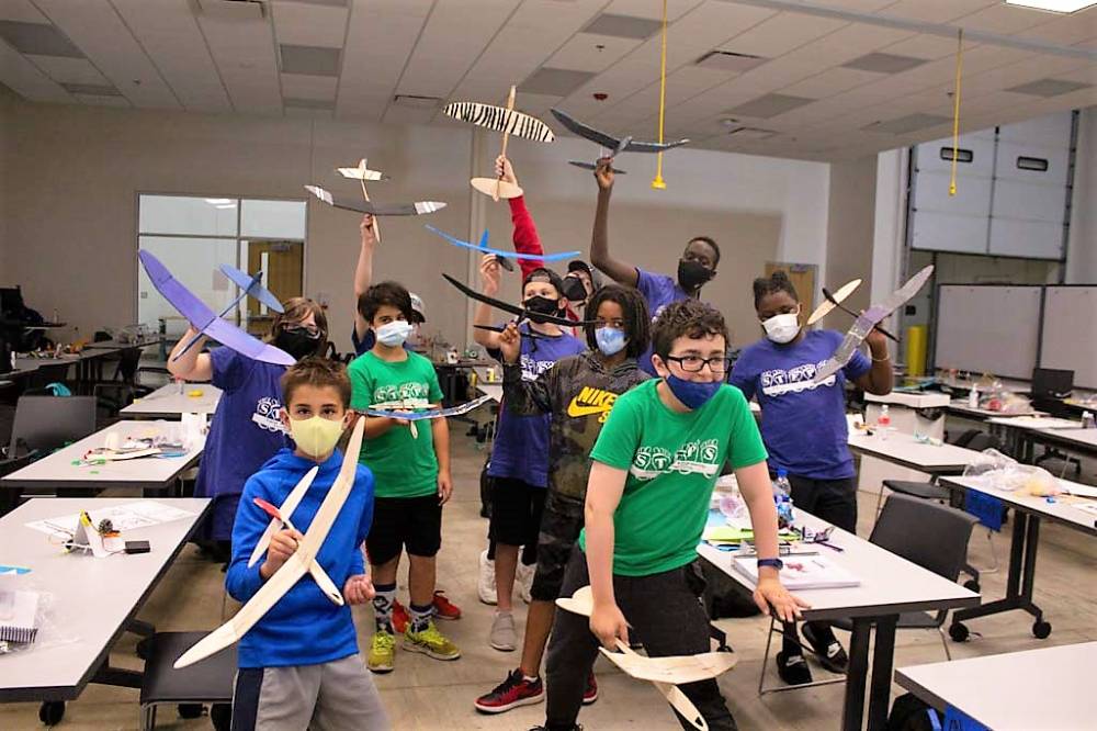 Campers take a silly photo with their completed airplanes